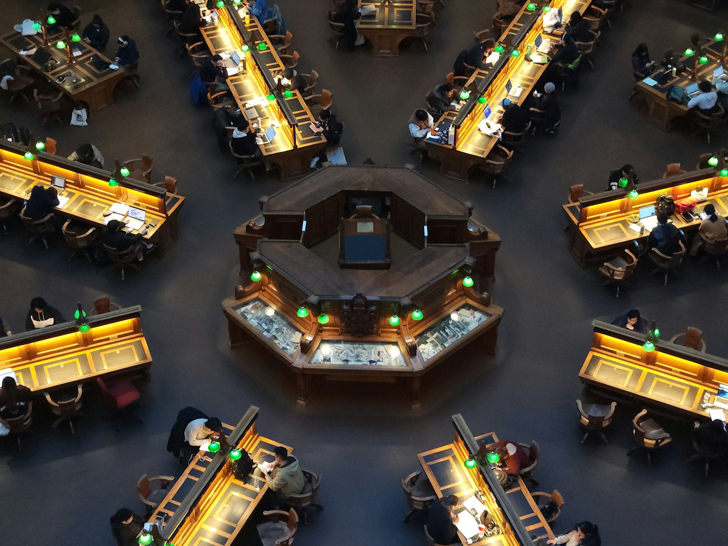 Students studying at desks in a large, ornate library.